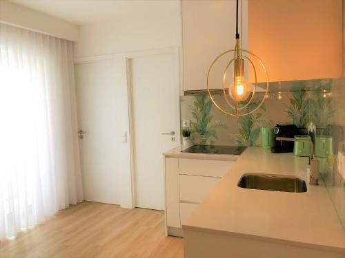 a kitchen with a sink and a counter top at Apartamento Veneza Portuguesa - Coração de Aveiro in Aveiro