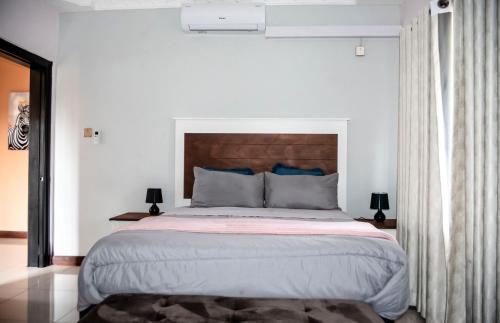 a bedroom with a large bed with a wooden headboard at Fabulous apartments in the new upmarkment and throbbing Lusaka area in Lusaka