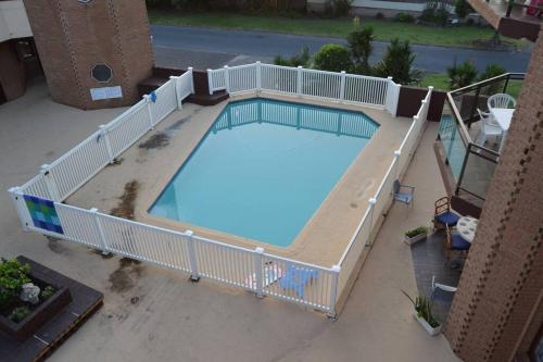 an overhead view of a large swimming pool with a white fence at 2Bed 2Bath Vacation home with pool close to beach in Margate