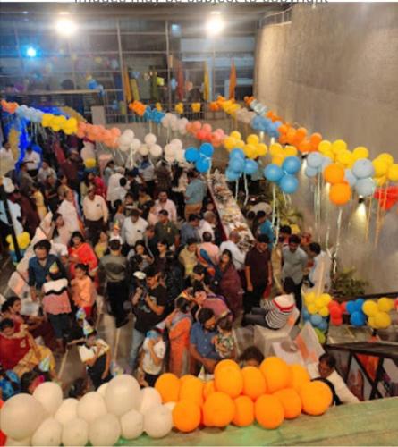 a crowd of people standing in a room with balloons at Sukh Sagar Hotel in Jaipur