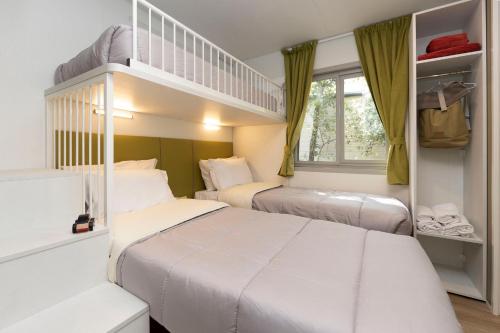 a bedroom with two beds and a bunk bed at hu Park Albatros Village in San Vincenzo