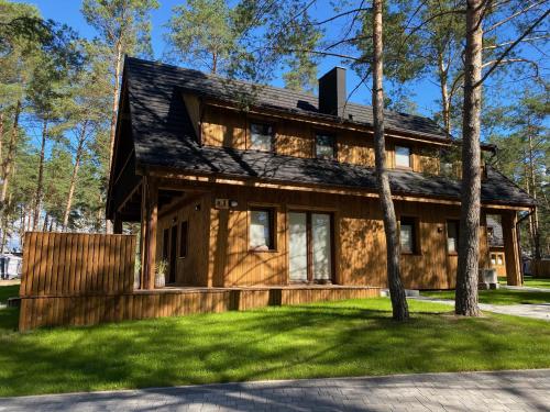 a log home with a black roof at Largo Lake Resort Kaszuby in Borsk