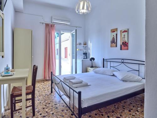 1 dormitorio con cama, mesa y escritorio en Pension Paros Anna Spanou, en Parikia