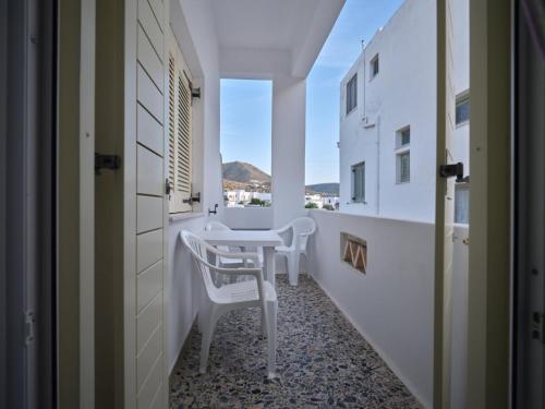 um corredor com uma mesa e cadeiras num quarto em Pension Paros Anna Spanou em Parikia