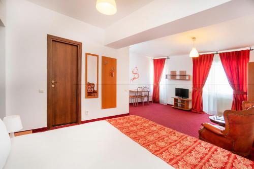 a hotel room with a bed and a living room at West Gate Studios in Bucharest