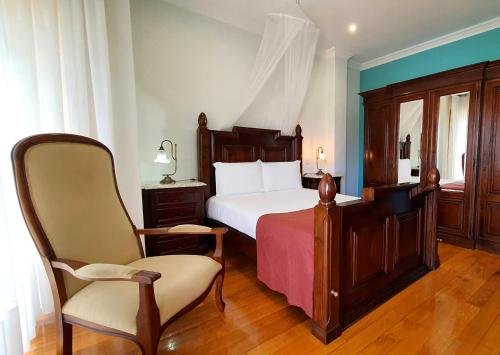 una camera con un letto e una sedia di MyStay - Villa Luísa a Vila do Conde