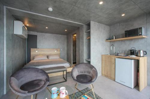 een slaapkamer met een bed en 2 stoelen. bij Cabane CELESTE Aigues-Mortes in Aigues-Mortes