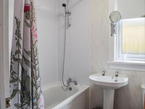 a bathroom with a sink and a toilet and a bath tub at Meadow View in Lochgelly