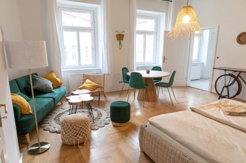sala de estar con sofá verde y mesa en Arbio Apartments near Mariahilferstraße, en Viena