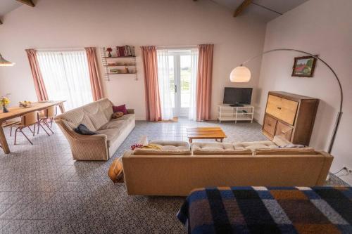 sala de estar con sofá y mesa en De Kaasmakerij - Ruim vakantiehuisje op Huize Blokland, en Hem