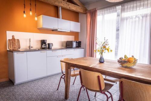 een keuken met een tafel en een fruitschaal bij De Kaasmakerij - Ruim vakantiehuisje op Huize Blokland in Hem