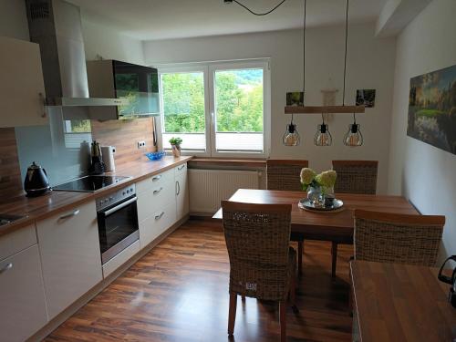 a kitchen with a wooden table and a dining room at Haus Luise Weber in Hilders