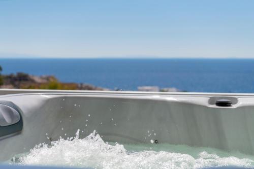 a bathtub full of water with the ocean in the background at Captain View in Ano Syros