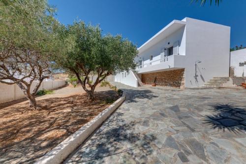 biały budynek z drzewami przed nim w obiekcie Captain View w mieście Ano Syros