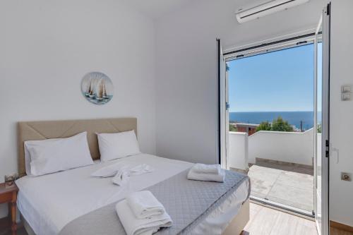 sypialnia z łóżkiem z białymi ręcznikami w obiekcie Captain View w mieście Ano Syros