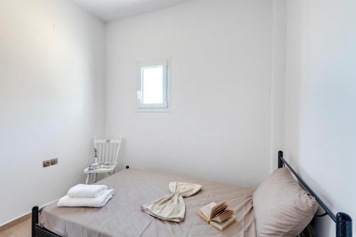 a bedroom with a bed with towels and a chair at Captain View in Ano Syros