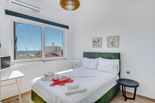 a bedroom with a bed and a desk and a window at Captain View in Ano Syros