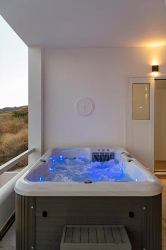 a bath tub with blue water in a room at Captain View in Ano Syros