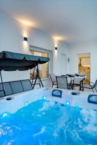 a hot tub in a room with a table and chairs at Captain View in Ano Syros