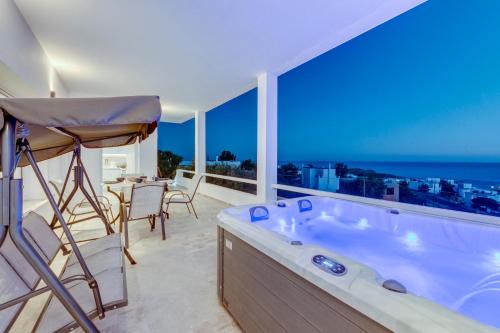 a bathroom with a large tub with a view of the ocean at Captain View in Ano Syros