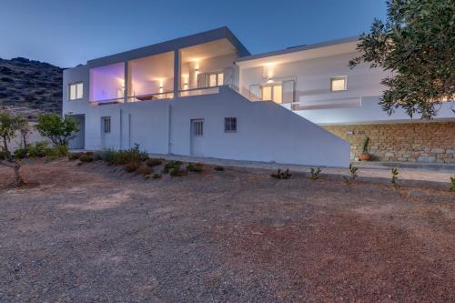 a large white house with a stone wall at Captain View in Ano Syros