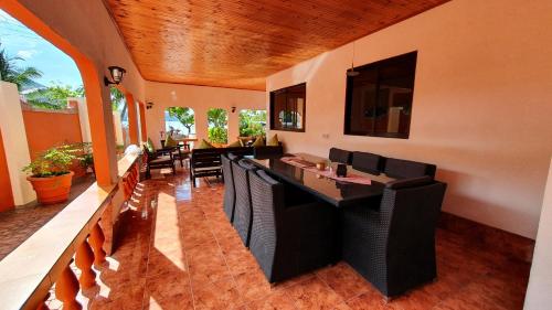 a dining room with a table and black chairs at Villa Milou in Baie Sainte Anne