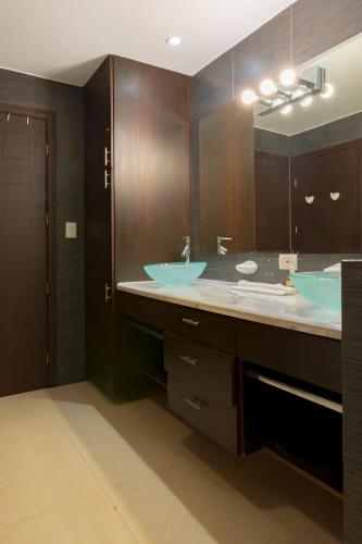 a bathroom with two sinks and a large mirror at Diamante del Sol Ocean front condos, Micasas in Jacó