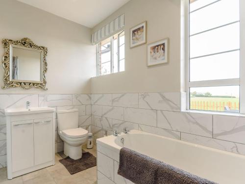 La salle de bains est pourvue d'une baignoire, de toilettes et d'un lavabo. dans l'établissement Henrys Retreat, à Ingoldsby