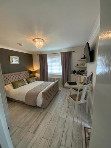 una camera con letto, tavolo e scrivania di THE KNIGHTWOOD OAK a Luxury King Size En-Suite Space - LYMINGTON NEW FOREST with Totally Private Entrance - Key Box entry - Free Parking & Private Outdoor Seating Area - Town ,Shops , Pubs & Solent Way Walking Distance & Complimentary Breakfast Items a Lymington