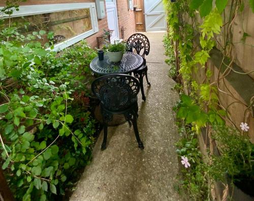a table and chairs in a garden with plants at THE KNIGHTWOOD OAK a Luxury King Size Bed - En-Suite Space - LYMINGTON NEW FOREST with Totally Private Entrance - Key Box entry - Free Parking & Private Outdoor Seating Area - Town ,Shops , Pubs & Solent Way Walking Distance & Complimentary Breakfast in Lymington