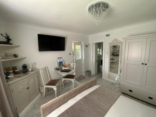 a living room with a bed and a chandelier at THE KNIGHTWOOD OAK a Luxury King Size Bed - En-Suite Space - LYMINGTON NEW FOREST with Totally Private Entrance - Key Box entry - Free Parking & Private Outdoor Seating Area - Town ,Shops , Pubs & Solent Way Walking Distance & Complimentary Breakfast in Lymington