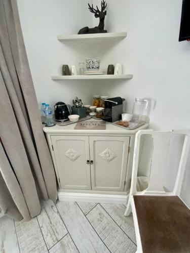 a kitchen with white cabinets and a counter top at THE KNIGHTWOOD OAK a Luxury King Size Bed - En-Suite Space - LYMINGTON NEW FOREST with Totally Private Entrance - Key Box entry - Free Parking & Private Outdoor Seating Area - Town ,Shops , Pubs & Solent Way Walking Distance & Complimentary Breakfast in Lymington