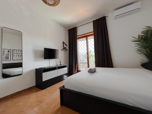 - une chambre avec un grand lit blanc et une télévision dans l'établissement Appartamento di design, à Rome