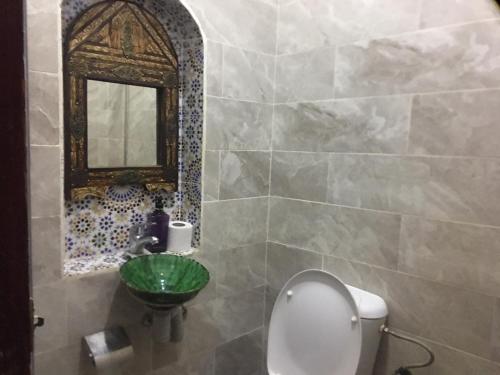 a bathroom with a toilet and a sink and a mirror at Karim Sahara in Zagora