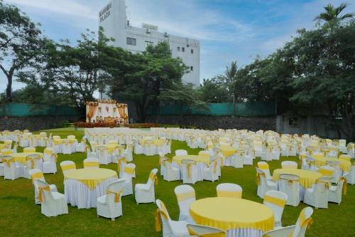 a group of white tables and chairs in a field at Hotel Bramha Inn Aundh Wakad Rooms Restaurant Banquet in Dāpuri