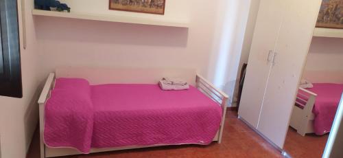 um pequeno quarto com uma cama rosa em Villa Lara 