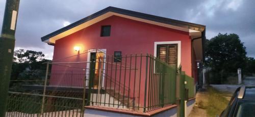 uma pequena casa vermelha com um portão em frente em Villa Lara 
