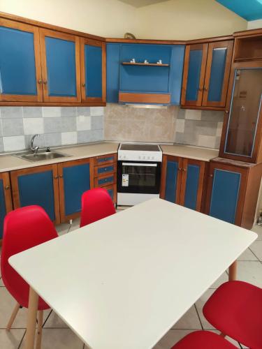 a kitchen with a white table and red chairs at GCM 1 ROOMS kentro k parking in Katerini