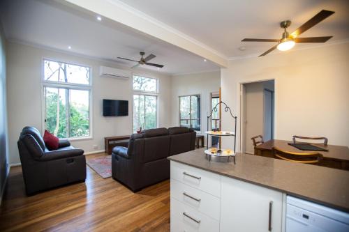 a kitchen and living room with two chairs and a table at Mt Cotton Retreat in Mount Cotton