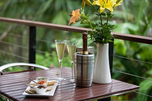 a wooden table with champagne glasses and a vase with flowers at Mt Cotton Retreat in Mount Cotton