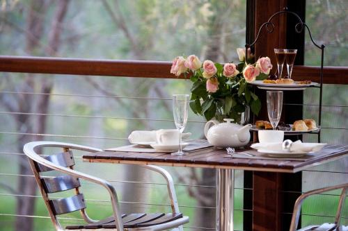 a table with a vase of pink roses on it at Mt Cotton Retreat in Mount Cotton