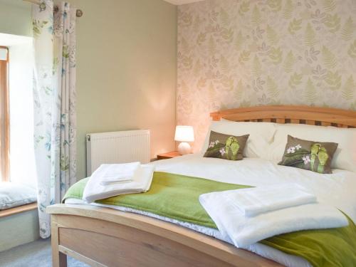 a bedroom with a bed with towels on it at Ty Celyn Farmhouse in Pont Yates