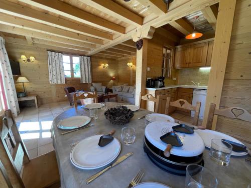 ein Esszimmer mit einem Tisch in einer Hütte in der Unterkunft PATURAGE Demi chalet 4 chambres in La Clusaz