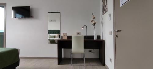 a desk with a white chair in a room at Suites Direzionale Carpi in Carpi
