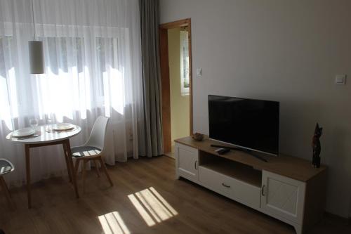 sala de estar con TV de pantalla plana y mesa en Przytulny, spokojny, wyposażony apartament, en Poznan