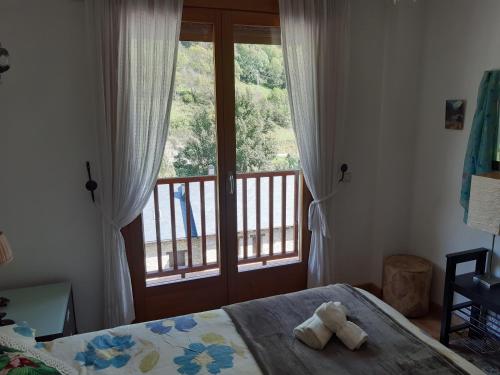 1 dormitorio con cama y ventana grande en Apartamento en Pirineos, en Bielsa