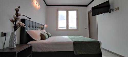 a bedroom with a bed with a window and a television at Suites Direzionale Carpi in Carpi