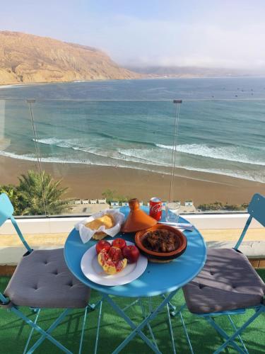 a plate of food on a table with a view of the beach at Imsouane Magic House in Imsouane