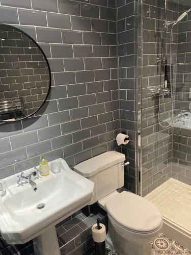 a bathroom with a toilet and a sink and a shower at The Chequers Inn in Froggatt