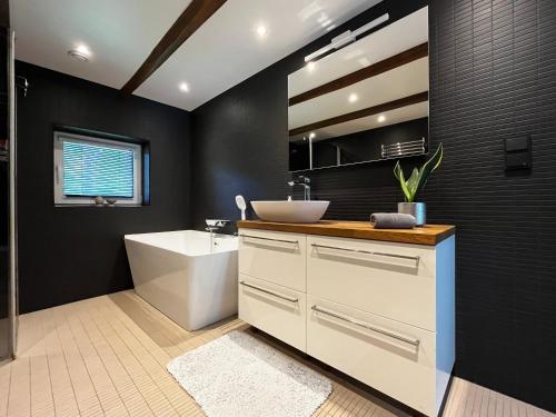 a bathroom with a sink and a tub and a toilet at Villa Männituka külalistemaja in Kirikuküla
